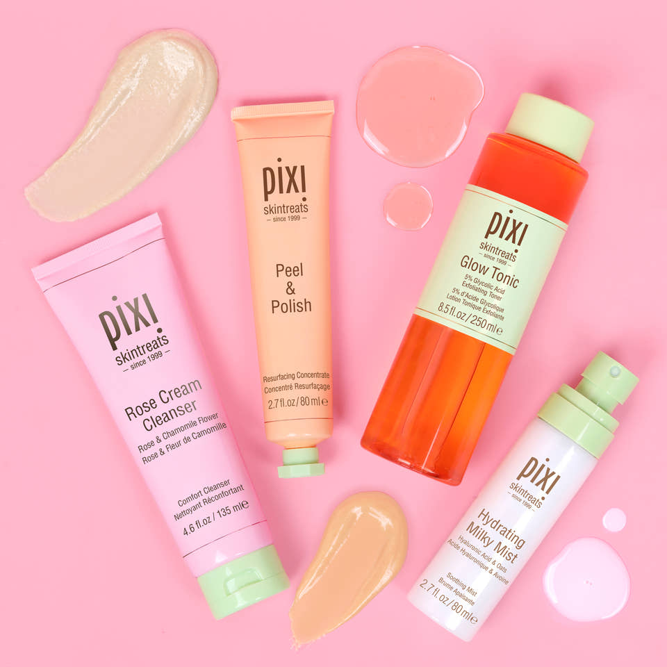 Pixi Glow Starter Routine skincare set arranged on a solid pink background: Rose Cream Cleanser in a pink tube, Peel & Polish in a peach tube, Hydrating Milky Mist in a white bottle with a mint cap, and Glow Tonic in an orange bottle with a pale green cap - top view with texture examples alongside each product. view 2