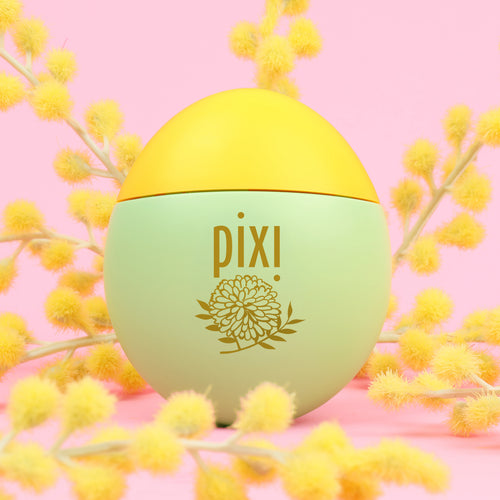 Pixi HandHero PixiMimosa scented hand lotion with mimosa blooms on a pink background view 1